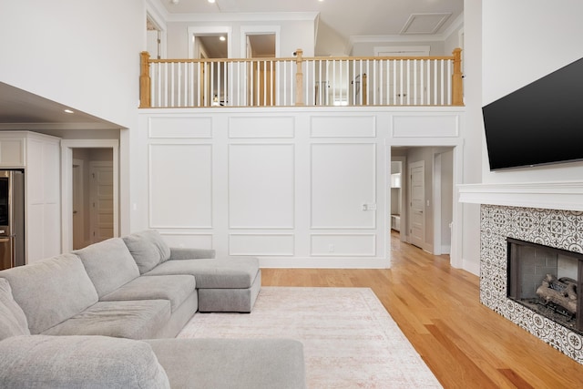 10607 Flicker Way, Apison, TN 37302 - living area featuring a high ceiling, crown molding, light wood-style floors, a tile fireplace, and recessed lighting