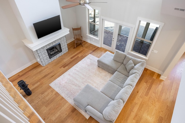 10607 Flicker Way, Apison, TN 37302 - living room featuring french doors, wood finished floors, ceiling fan, a tiled fireplace, and a high ceiling