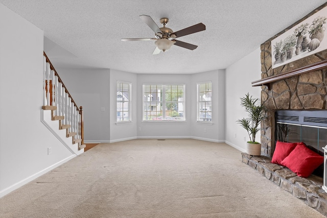 8616 Oak View Dr, Chattanooga, TN 37421 - unfurnished living room featuring carpet, ceiling fan, a textured ceiling, a stone fireplace, and stairs