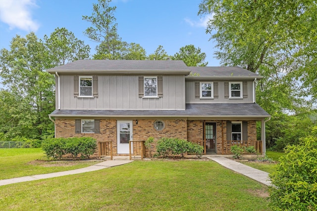 1433 Stratton Place Dr, Chattanooga, TN 37421 - view of front facade featuring a front lawn, a porch, brick siding, and board and batten siding