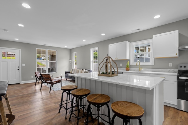 2001 Vine St, Chattanooga, TN 37404 - kitchen featuring stainless steel range with electric cooktop, a kitchen bar, recessed lighting, a kitchen island, and white cabinetry