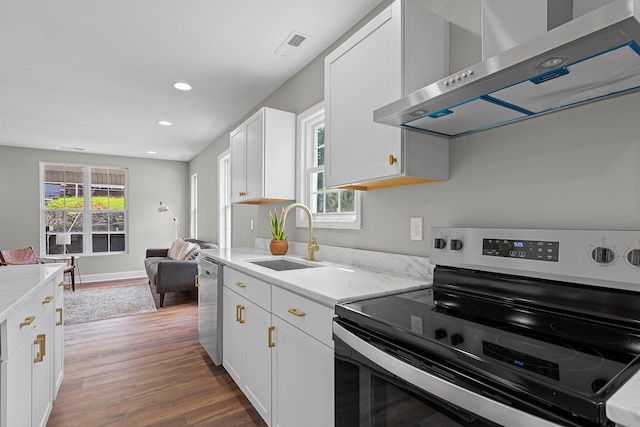 2001 Vine St, Chattanooga, TN 37404 - kitchen featuring appliances with stainless steel finishes, exhaust hood, wood finished floors, white cabinetry, and recessed lighting