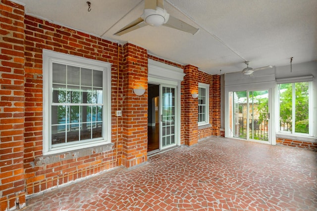 208 S Palisades Dr, Signal Mountain, TN 37377 - unfurnished sunroom featuring ceiling fan, brick wall, and stone flooring