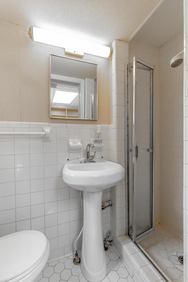 208 S Palisades Dr, Signal Mountain, TN 37377 - bathroom featuring a stall shower, tile walls, tile patterned flooring, and wainscoting
