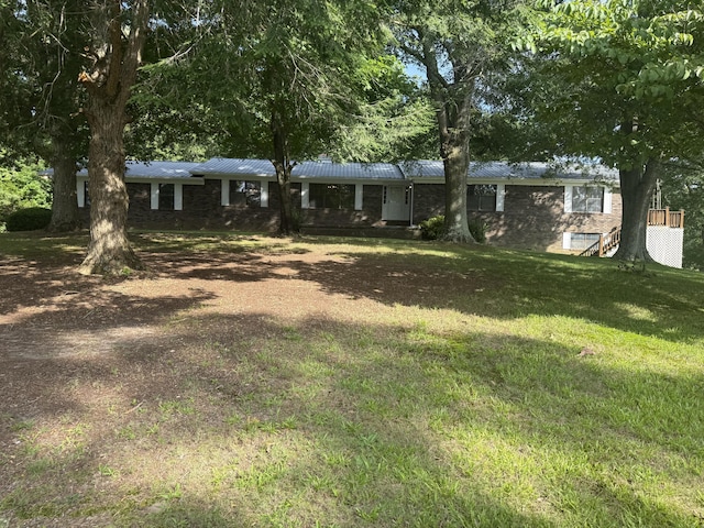 30551 Al Al Unit 71, Bryant, AL 35958 - view of front facade with a front lawn, a metal roof, brick siding, and dirt driveway