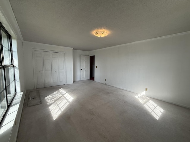 30551 Al Al Unit 71, Bryant, AL 35958 - unfurnished bedroom featuring light colored carpet, a textured ceiling, crown molding, and a closet