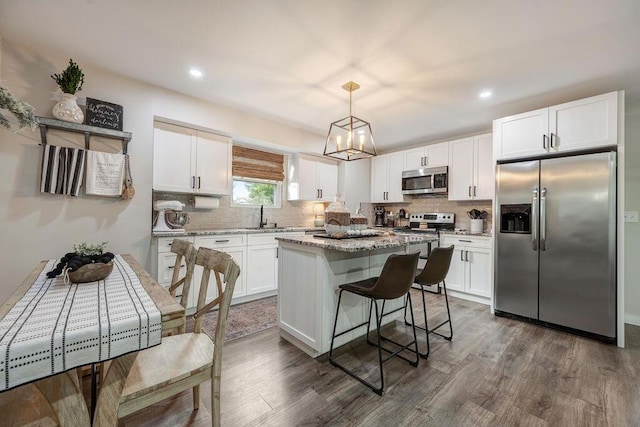 414 N Three Notch Rd, Ringgold, GA 30736 - kitchen with stainless steel appliances, dark wood-type flooring, white cabinetry, decorative backsplash, and a kitchen island