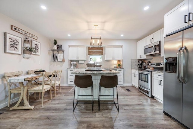 414 N Three Notch Rd, Ringgold, GA 30736 - kitchen with appliances with stainless steel finishes, a kitchen island, decorative backsplash, white cabinetry, and recessed lighting