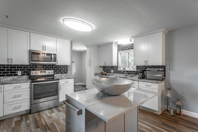 409 Caraway Turn, Chattanooga, TN 37415 - kitchen with stainless steel appliances, tasteful backsplash, dark wood finished floors, and white cabinets