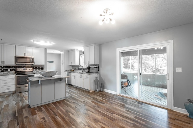 409 Caraway Turn, Chattanooga, TN 37415 - kitchen featuring stainless steel appliances, tasteful backsplash, white cabinets, dark wood finished floors, and light countertops