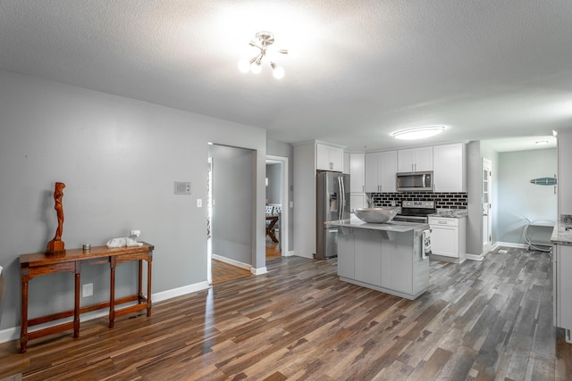 409 Caraway Turn, Chattanooga, TN 37415 - kitchen with appliances with stainless steel finishes, dark wood-type flooring, white cabinetry, tasteful backsplash, and a center island