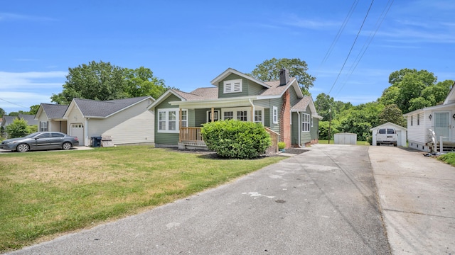 1514 Prigmore Rd, Chattanooga, TN 37412 - view of front of house with covered porch, concrete driveway, a chimney, a front lawn, and a detached garage