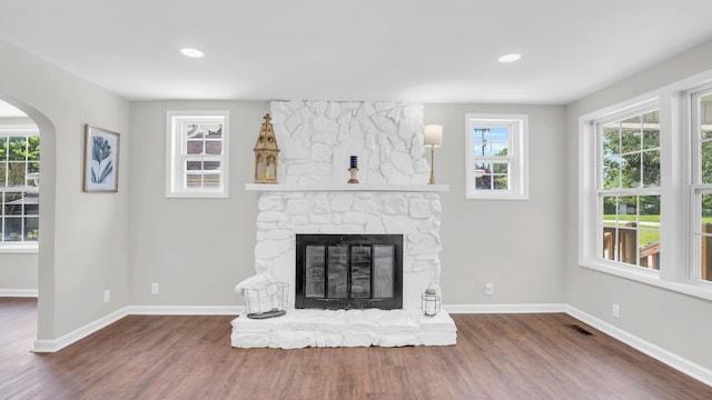 1514 Prigmore Rd, Chattanooga, TN 37412 - unfurnished living room featuring wood finished floors, arched walkways, a stone fireplace, and recessed lighting