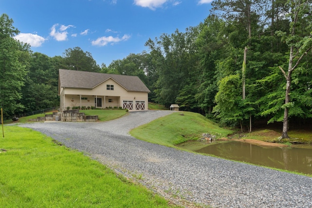 210 Gordon Dr, Chatsworth, GA 30705 - view of front of home featuring gravel driveway, a front yard, a forest view, and stucco siding