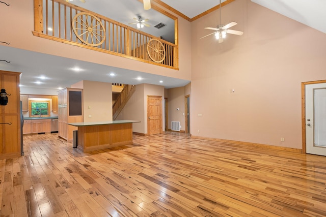 210 Gordon Dr, Chatsworth, GA 30705 - unfurnished living room featuring light wood-style floors, a high ceiling, a ceiling fan, and stairs