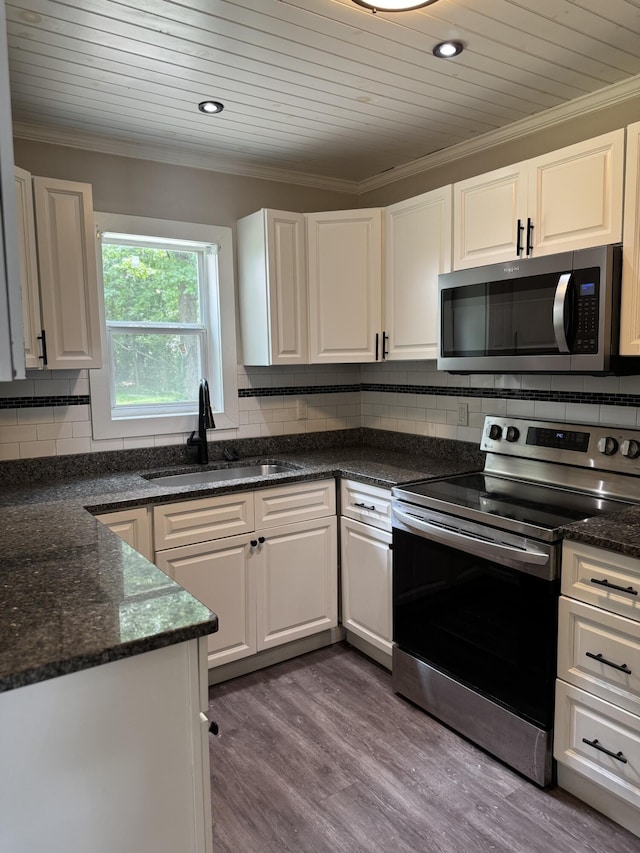 115 Palm Beach Ave, Rossville, GA 30741 - kitchen with stainless steel appliances, crown molding, white cabinets, dark wood-style flooring, and tasteful backsplash