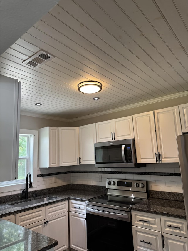 115 Palm Beach Ave, Rossville, GA 30741 - kitchen with stainless steel appliances, white cabinetry, decorative backsplash, crown molding, and dark stone counters
