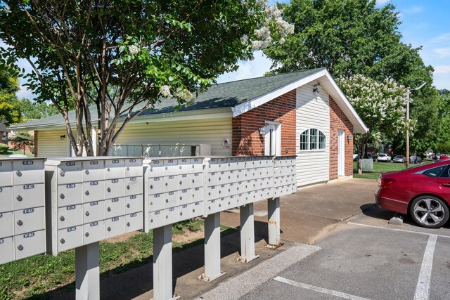 900 Mountain Creek Rd Unit E66, Chattanooga, TN 37405 - view of home's exterior featuring mail area, a shingled roof, brick siding, and uncovered parking