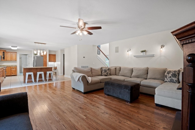 7470 Jester Ct, Ooltewah, TN 37363 - living area featuring ceiling fan, stairway, light wood-style floors, and a chandelier