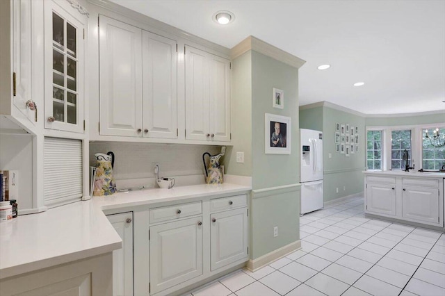 5 Woodland Way, Chattanooga, TN 37419 - kitchen featuring white refrigerator with ice dispenser, light countertops, light tile patterned floors, glass insert cabinets, and crown molding