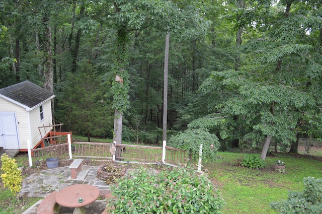 8211 Troubadour Way, Ooltewah, TN 37363 - view of yard featuring a storage unit, an outdoor fire pit, a wooded view, and a patio area