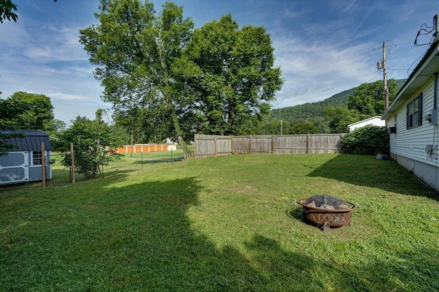 1209 Hickory Ave, South Pittsburg, TN 37380 - fenced backyard with an outdoor fire pit and a storage shed