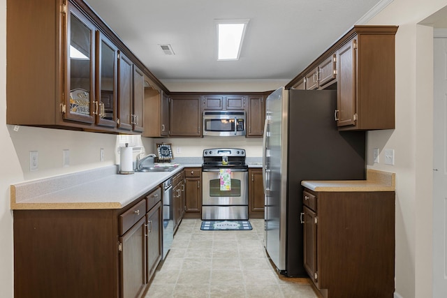 4429 Kayla Cir, Chattanooga, TN 37406 - kitchen with stainless steel appliances, light countertops, glass insert cabinets, dark brown cabinets, and ornamental molding