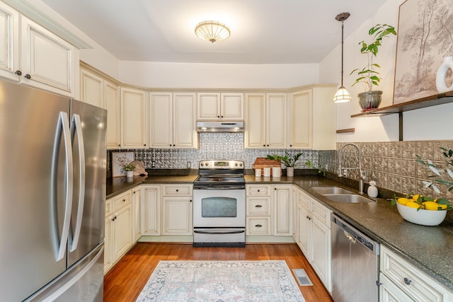 4503 Saint Elmo Ave, Chattanooga, TN 37409 - kitchen with appliances with stainless steel finishes, cream cabinets, under cabinet range hood, and light wood-type flooring