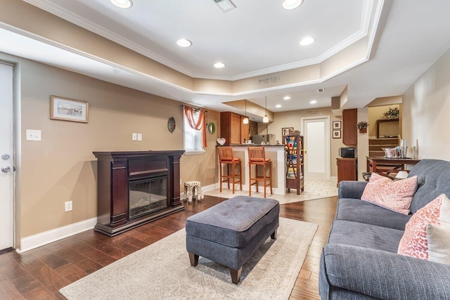 234 Holcomb Rd, Ringgold, GA 30736 - living room with crown molding, dark wood-style flooring, recessed lighting, a tray ceiling, and a glass covered fireplace