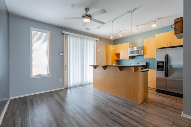 277 W 19th St, Chattanooga, TN 37408 - kitchen with appliances with stainless steel finishes, a breakfast bar area, dark countertops, and dark wood-style flooring