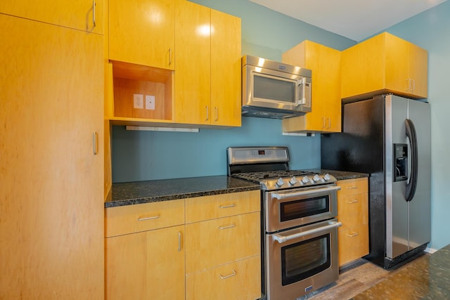277 W 19th St, Chattanooga, TN 37408 - kitchen featuring appliances with stainless steel finishes, dark stone counters, open shelves, and wood finished floors