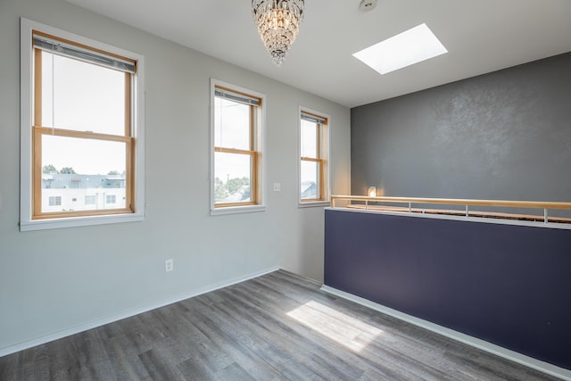 277 W 19th St, Chattanooga, TN 37408 - unfurnished room featuring a skylight, wood finished floors, a chandelier, and a smoke detector
