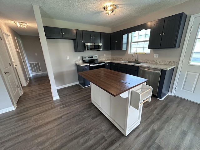 4594 Lee Dr NW, Cleveland, TN 37312 - kitchen with appliances with stainless steel finishes, butcher block counters, dark cabinets, dark wood finished floors, and a textured ceiling