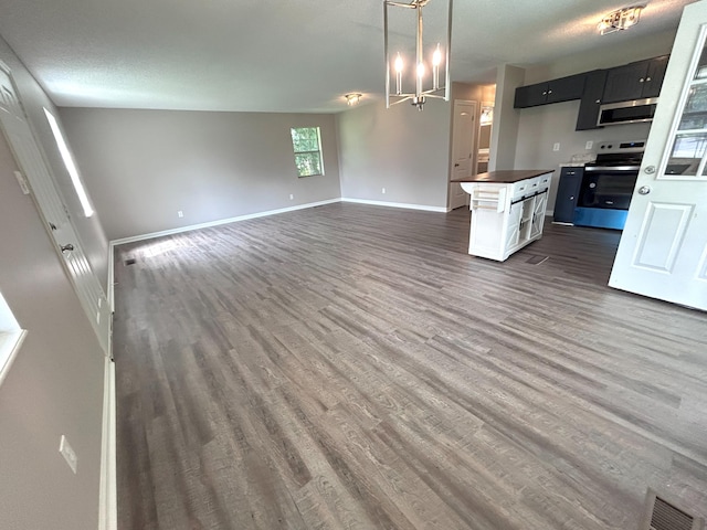 4594 Lee Dr NW, Cleveland, TN 37312 - kitchen with appliances with stainless steel finishes, dark wood finished floors, dark cabinetry, open floor plan, and dark countertops