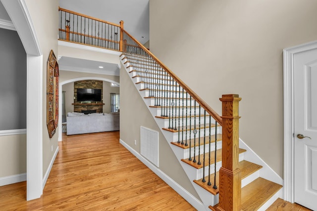 231 Turkey Run, Flintstone, GA 30725 - staircase with arched walkways, a towering ceiling, wood finished floors, crown molding, and a stone fireplace