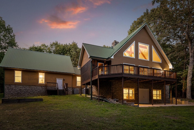 68 Bluff View Dr, Dunlap, TN 37327 - back of property at dusk with stone siding, a yard, and a metal roof