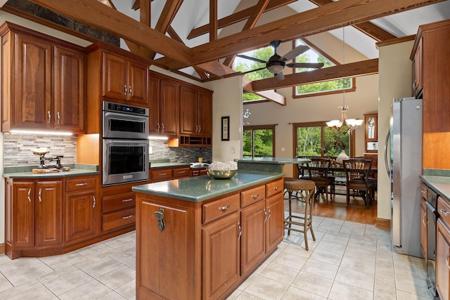68 Bluff View Dr, Dunlap, TN 37327 - kitchen with appliances with stainless steel finishes, dark countertops, a kitchen island, light tile patterned floors, and backsplash