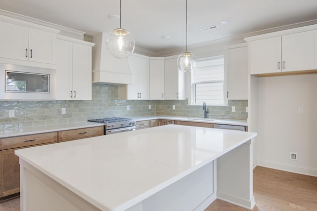 101 Lemonade St, Chattanooga, TN 37421 - kitchen with stainless steel appliances, a center island, light wood-style flooring, premium range hood, and backsplash