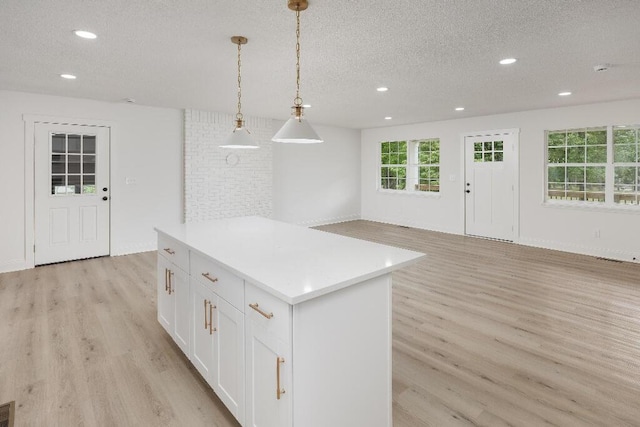 8208 Hixson Springs Rd, Signal Mountain, TN 37377 - kitchen with light wood finished floors, a textured ceiling, recessed lighting, white cabinets, and a center island