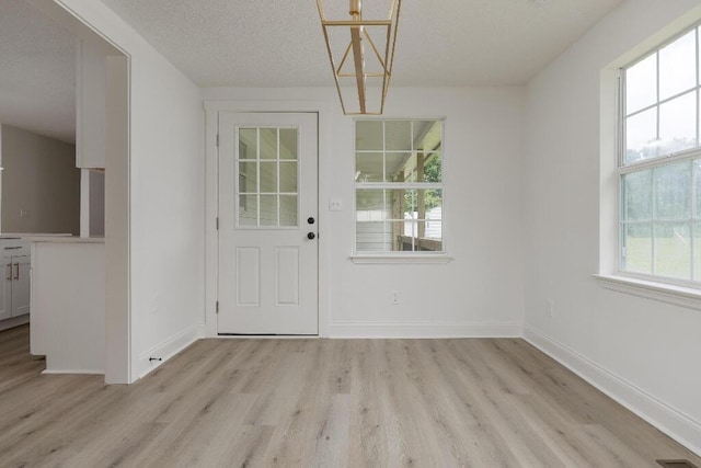8208 Hixson Springs Rd, Signal Mountain, TN 37377 - unfurnished dining area with light wood-style flooring, a chandelier, and a textured ceiling