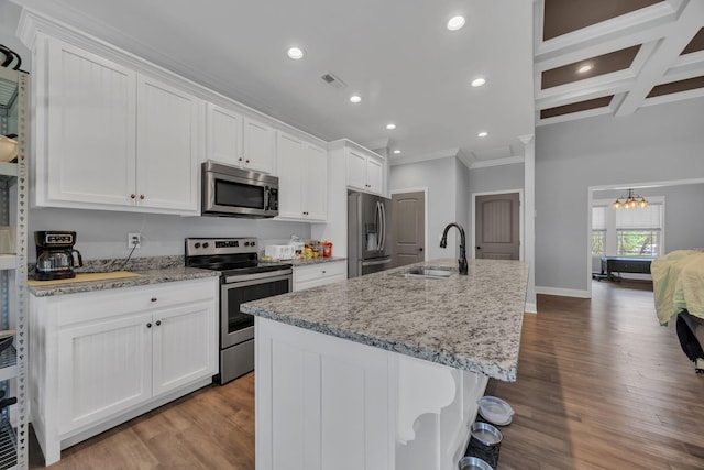 386 Twelve Oaks Dr, Rock Spring, GA 30739 - kitchen with appliances with stainless steel finishes, ornamental molding, wood finished floors, white cabinetry, and an island with sink