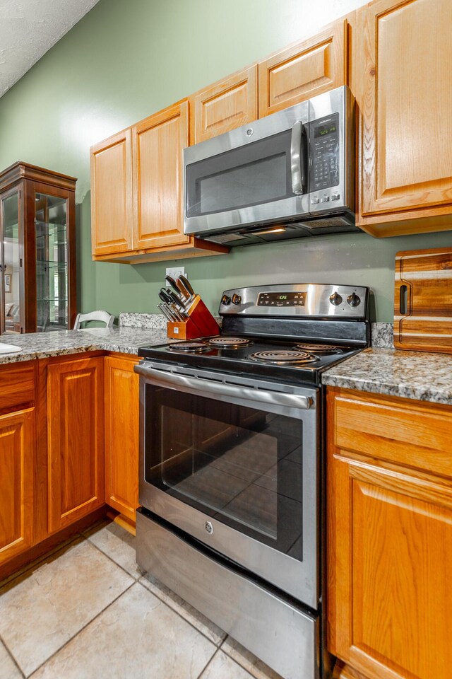 1027 Crestridge Dr, Rossville, GA 30741 - kitchen featuring stainless steel appliances, light tile patterned flooring, and light stone countertops