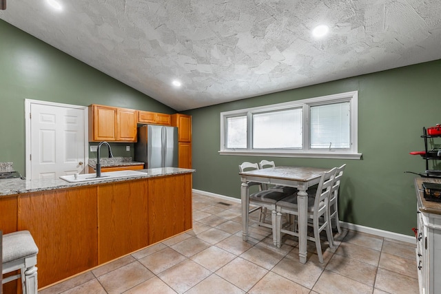 1027 Crestridge Dr, Rossville, GA 30741 - kitchen featuring freestanding refrigerator, lofted ceiling, a peninsula, light tile patterned floors, and recessed lighting