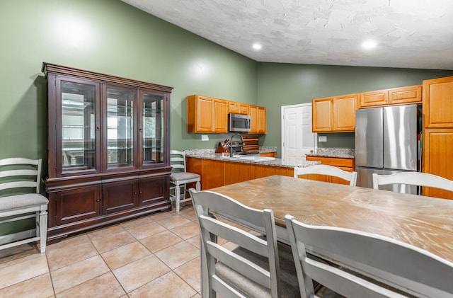 1027 Crestridge Dr, Rossville, GA 30741 - kitchen with appliances with stainless steel finishes, lofted ceiling, light tile patterned floors, and a textured ceiling