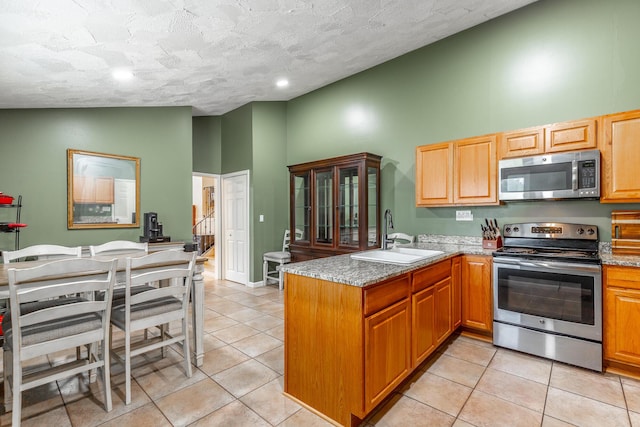 1027 Crestridge Dr, Rossville, GA 30741 - kitchen featuring stainless steel appliances, a peninsula, high vaulted ceiling, light tile patterned floors, and a textured ceiling