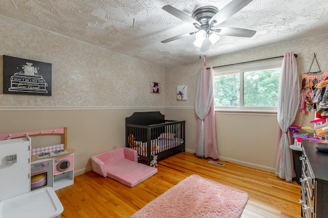 1027 Crestridge Dr, Rossville, GA 30741 - bedroom with wood finished floors, a nursery area, and a ceiling fan
