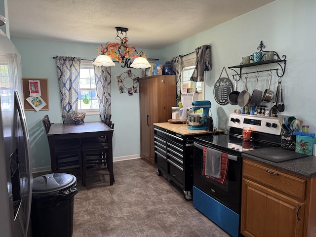 78 Mcdonough St, Dunlap, TN 37327 - kitchen with stainless steel appliances, a chandelier, brown cabinets, dark countertops, and hanging light fixtures
