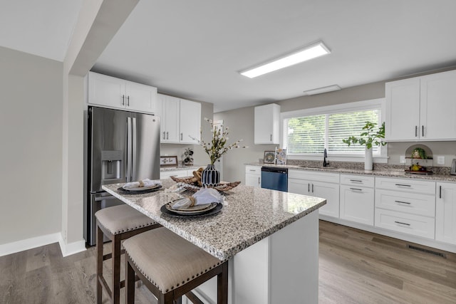 185 Block Rd, Rossville, GA 30741 - kitchen with stainless steel fridge, dishwashing machine, a kitchen bar, light stone counters, and white cabinets