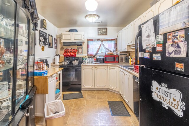 4433 Live Oak Ln, Chattanooga, TN 37411 - kitchen with black appliances, under cabinet range hood, light countertops, light tile patterned floors, and white cabinets