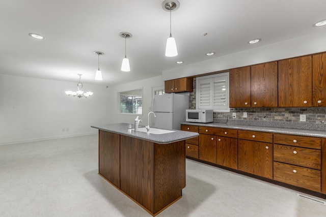 2046 N Concord Rd, Chattanooga, TN 37421 - kitchen with white appliances, a chandelier, tasteful backsplash, hanging light fixtures, and a kitchen island with sink